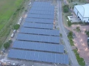 Vista aérea de um telhado industrial extenso coberto com painéis solares