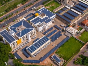 Vista aérea de um complexo de edifícios com telhados cobertos por painéis solares