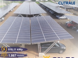 Vista aérea de uma grande instalação de painéis solares em Araraquara-SP, cobrindo o estacionamento da empresa Cutrale