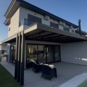 Pergolado metálico com estrutura em aço, brise em madeira nobre e cobertura em vidro temperado. Ideal para área externa, oferecendo proteção, iluminação natural e um acabamento moderno e elegante.