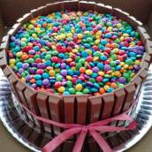 Bolo branco com recheio de brigadeiro de leite ninho, envolto por kit kat e coberto com confetes!!