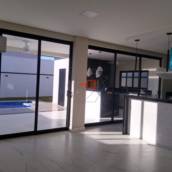 Sala, cozinha e área gourmet integradas.