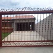 Portão basculante,  social, grade e lixeira com detalhes em arabesco.