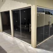 Porta 4 folhas de vidro fumê com puxadores cromados, Porta 2 folhas de vidro fumê com puxador H tubolar, Vidros fixos fumê.