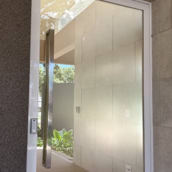 Comprar o produto de Porta de Alumínio Branco Linha 42 com Vidro Refletivo Champanhe e Película Jateada no lado interno à casa e Puxador Inox 1500mm - Instalação realizada no Condomínio Spazio Verde em Portas de Alumínio pela empresa VerticalGlass - Esquadrias de Alumínio e Vidros em Lençóis Paulista, SP por Solutudo