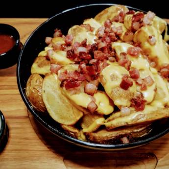 Comprar o produto de Porção de batata rústica com cheddar e bacon picado. em Porções em Botucatu, SP por Solutudo