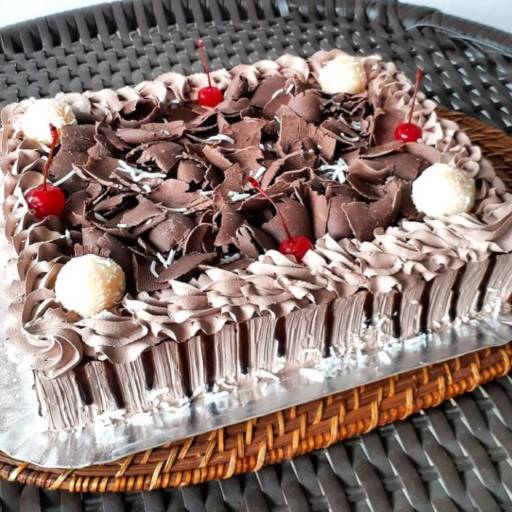 Bolo trufado decorado com raspas de chocolate e cerejas