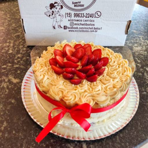 Bolo recheado com creme de leite ninho e morangos, coberto com creme branco e morangos.