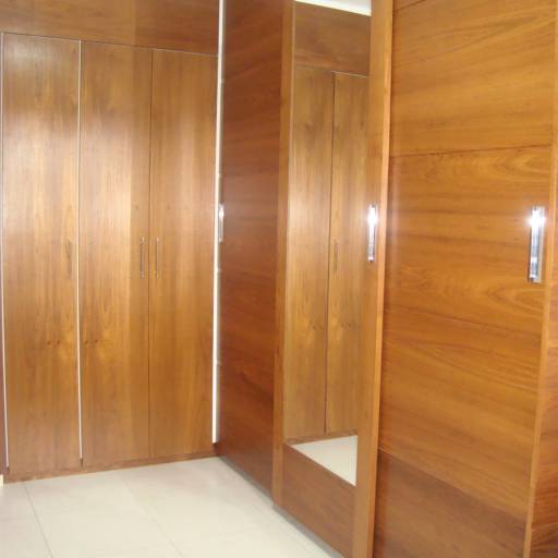 Móvel em madeira de freijó, com portas de correr sendo uma espelhada