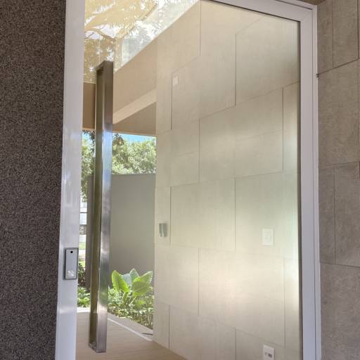 Porta de Alumínio Branco Linha 42 com Vidro Refletivo Champanhe e Película Jateada no lado interno à casa e Puxador Inox 1500mm - Instalação realizada no Condomínio Spazio Verde