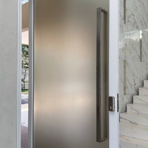 Porta de Alumínio Branco Linha 42 com Vidro Refletivo Champanhe e Película Jateada no lado interno à casa e Puxador Inox 1500mm - Instalação realizada no Condomínio Spazio Verde por VerticalGlass - Esquadrias de Alumínio e Vidros