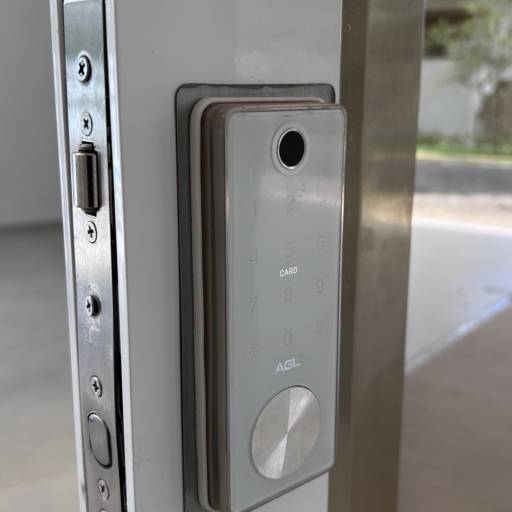 Porta de Alumínio Branco Linha 42 com Vidro Refletivo Champanhe e Película Jateada no lado interno à casa e Puxador Inox 1500mm - Instalação realizada no Condomínio Spazio Verde por VerticalGlass - Esquadrias de Alumínio e Vidros
