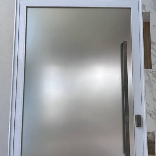 Porta de Alumínio Branco Linha 42 com Vidro Refletivo Champanhe e Película Jateada no lado interno à casa e Puxador Inox 1500mm - Instalação realizada no Condomínio Spazio Verde por VerticalGlass - Esquadrias de Alumínio e Vidros