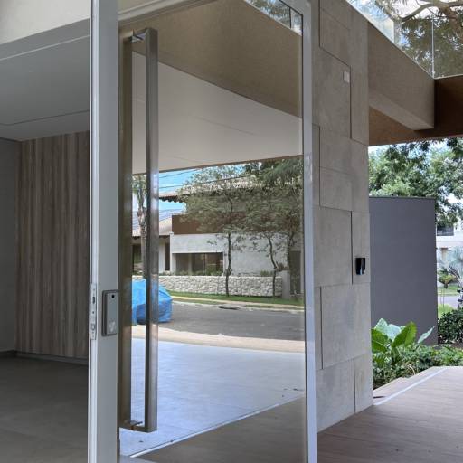 Porta de Alumínio Branco Linha 42 com Vidro Refletivo Champanhe e Película Jateada no lado interno à casa e Puxador Inox 1500mm - Instalação realizada no Condomínio Spazio Verde por VerticalGlass - Esquadrias de Alumínio e Vidros