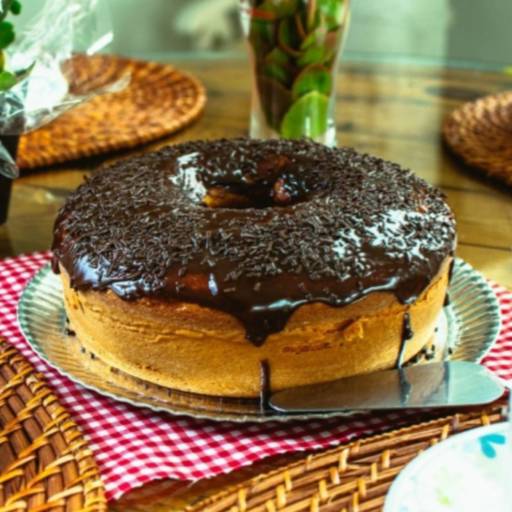 Bolo de cenoura coberto com calda de chocolate e decorado com granulados.